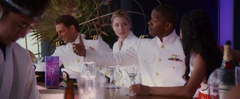 Movie still from “Stealth” (2005), directed by Rob Cohen – A group of people sitting at a table with drinks; Medium shot, Over the shoulder angle