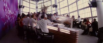 Movie still from “Stealth” (2005), directed by Rob Cohen – A group of people sitting at a table in front of a window; Wide shot, High angle