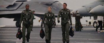 Movie still from “Stealth” (2005), directed by Rob Cohen – A man and a woman walking on a tarmac with a fighter jet in the background; Medium shot, Low angle
