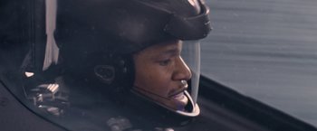 Movie still from “Stealth” (2005), directed by Rob Cohen – A man wearing a motorcycle helmet is sitting in a car; Close Up shot, Low angle
