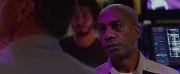 Movie still from “Stealth” (2005), directed by Rob Cohen – A man with a bald head is looking at the camera; Close Up shot, Over the shoulder angle