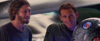 Movie still from “Stealth” (2005), directed by Rob Cohen – A man and a woman smiling for the camera; Close Up shot, Over the shoulder angle