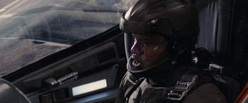 Movie still from “Stealth” (2005), directed by Rob Cohen – A man wearing a motorcycle helmet in a vehicle; Close Up shot, Over the shoulder angle