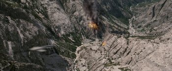 Movie still from “Stealth” (2005), directed by Rob Cohen – An aerial view of a mountain with a fire coming out of it; Extreme Wide shot, Overhead angle