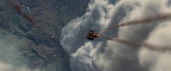 Movie still from “Stealth” (2005), directed by Rob Cohen – A person is flying in the air while holding onto a parachute; Extreme Wide shot, Overhead angle