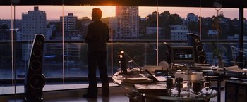 Movie still from “Stealth” (2005), directed by Rob Cohen – A man standing in front of a large window with a view of a city; Wide shot, Over the shoulder angle