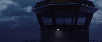 Movie still from “Stealth” (2005), directed by Rob Cohen – A person sitting on top of a tower at night; Extreme Wide shot, Low angle