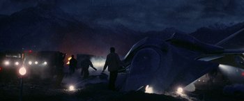 Movie still from “Stealth” (2005), directed by Rob Cohen – A group of people standing next to an airplane in the dark; Extreme Wide shot, High angle