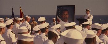 Movie still from “Stealth” (2005), directed by Rob Cohen – A group of men in uniform standing in front of an american flag; Medium shot, Over the shoulder angle