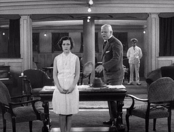 Movie still from “Steamboat Bill, Jr.” (1928), directed by Buster Keaton – A man and a woman standing in front of a table; Medium shot, Over the shoulder angle