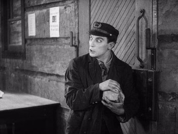 Movie still from “Steamboat Bill, Jr.” (1928), directed by Buster Keaton – A man holding a sandwich in his hands; Medium shot, Over the shoulder angle