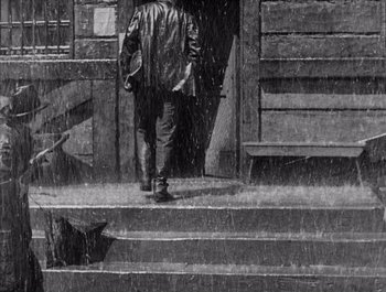 Movie still from “Steamboat Bill, Jr.” (1928), directed by Buster Keaton – A man walking down the steps in the rain; Wide shot, High angle