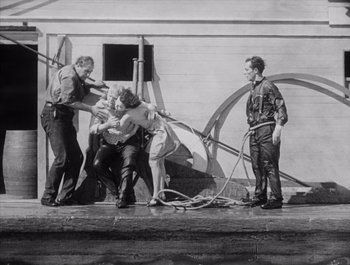 Movie still from “Steamboat Bill, Jr.” (1928), directed by Buster Keaton – A group of men standing next to each other on the ground; Wide shot, High angle