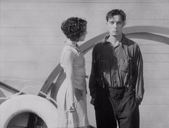 Movie still from “Steamboat Bill, Jr.” (1928), directed by Buster Keaton – A man and a woman standing next to each other in front of a building; Medium shot, Over the shoulder angle