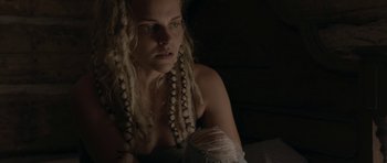 Movie still from “Still” (2018), directed by Takashi Doscher – A woman with dreadlocks is sitting in a dark room; Close Up shot, Low angle