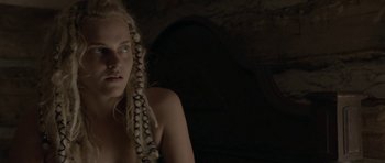 Movie still from “Still” (2018), directed by Takashi Doscher – A woman with long blonde hair is looking at the camera; Close Up shot, Over the shoulder angle
