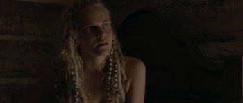 Movie still from “Still” (2018), directed by Takashi Doscher – A woman with blonde dreadlocks is looking at the camera; Close Up shot, Over the shoulder angle