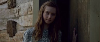 Movie still from “Still” (2018), directed by Takashi Doscher – A woman with long brown hair wearing a floral dress; Close Up shot, Over the shoulder angle