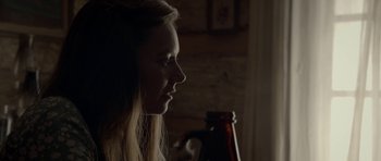 Movie still from “Still” (2018), directed by Takashi Doscher – A woman is looking to the side while holding a beer; Close Up shot, Over the shoulder angle