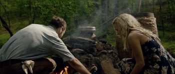 Movie still from “Still” (2018), directed by Takashi Doscher – A man and a woman cooking food over a fire; Medium shot, Over the shoulder angle