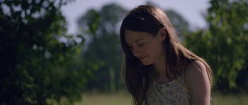 Movie still from “Still” (2018), directed by Takashi Doscher – A young girl with her eyes closed in a field; Close Up shot, Over the shoulder angle