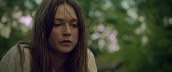 Movie still from “Still” (2018), directed by Takashi Doscher – A woman with long brown hair is looking down; Close Up shot, Low angle