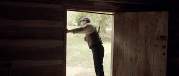Movie still from “Still” (2018), directed by Takashi Doscher – A man holding a sword in front of an open window; Wide shot, Over the shoulder angle