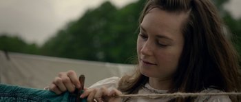 Movie still from “Still” (2018), directed by Takashi Doscher – A young woman is combing her hair outside; Close Up shot, Over the shoulder angle