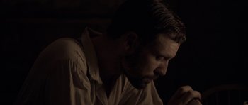 Movie still from “Still” (2018), directed by Takashi Doscher – A person wearing a shirt looking down; Close Up shot, Over the shoulder angle