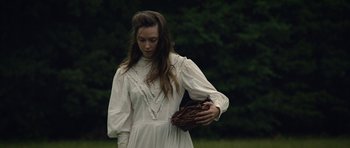 Movie still from “Still” (2018), directed by Takashi Doscher – A woman in a white dress holding a baseball glove; Medium shot, Over the shoulder angle