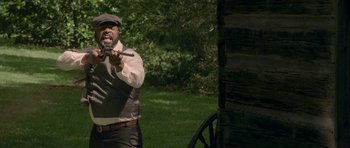 Movie still from “Still” (2018), directed by Takashi Doscher – A man in a hat and vest holding a pair of scissors in his hand; Medium shot, Over the shoulder angle