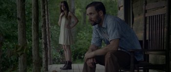 Movie still from “Still” (2018), directed by Takashi Doscher – A man and a woman standing next to each other on a porch; Medium shot, Over the shoulder angle