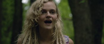 Movie still from “Still” (2018), directed by Takashi Doscher – A woman with dreads is looking at the camera; Close Up shot, Low angle