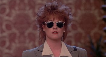 Movie still from “Stormy Monday” (1988), directed by Mike Figgis – A person wearing a suit and sunglasses; Close Up shot, Low angle