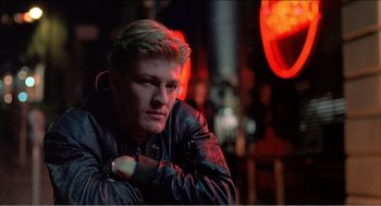 Movie still from “Stormy Monday” (1988), directed by Mike Figgis – A young man in a leather jacket posing for a picture; Close Up shot, Low angle