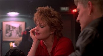 Movie still from “Stormy Monday” (1988), directed by Mike Figgis – A person sitting in front of a wall; Close Up shot, Low angle
