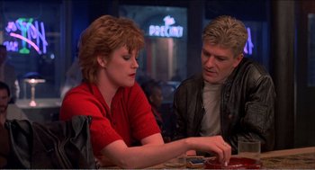 Movie still from “Stormy Monday” (1988), directed by Mike Figgis – A man and a woman sitting at a table in a restaurant; Medium shot, Over the shoulder angle