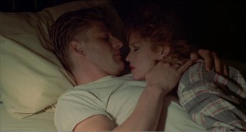 Movie still from “Stormy Monday” (1988), directed by Mike Figgis – A man and a woman laying in a bed together; Close Up shot, Overhead angle