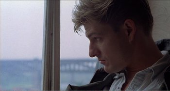 Movie still from “Stormy Monday” (1988), directed by Mike Figgis – A person looking out of a window; Close Up shot, Low angle