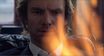 Movie still from “Stormy Monday” (1988), directed by Mike Figgis – A person wearing a suit and tie; Close Up shot, Low angle