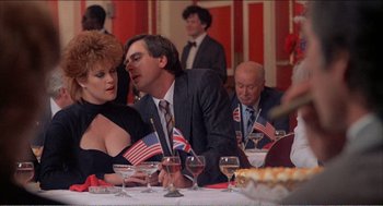 Movie still from “Stormy Monday” (1988), directed by Mike Figgis – A group of people sitting at a dinner table; Medium shot, Over the shoulder angle