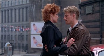 Movie still from “Stormy Monday” (1988), directed by Mike Figgis – A man and a woman standing next to each other; Medium shot, Low angle