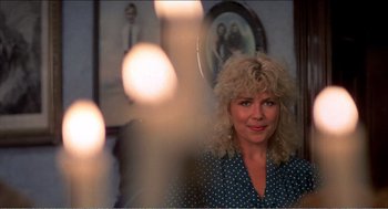 Movie still from “Stormy Monday” (1988), directed by Mike Figgis – A woman with blonde curly hair and a polka dot shirt; Close Up shot, Over the shoulder angle