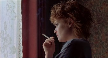 Movie still from “Stormy Monday” (1988), directed by Mike Figgis – A woman is smoking a cigarette in front of a window; Close Up shot, Low angle
