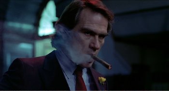 Movie still from “Stormy Monday” (1988), directed by Mike Figgis – A person smoking a cigar; Close Up shot, Low angle
