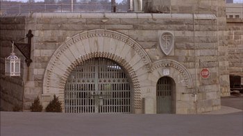 Movie still from “Straight Time” (1978), directed by Ulu Grosbard – An entrance to an old jail with a large arch; Extreme Wide shot, High angle