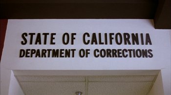 Movie still from “Straight Time” (1978), directed by Ulu Grosbard – A sign that reads state of california department of corrections; Wide shot, Low angle