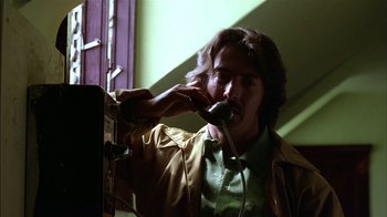 Movie still from “Straight Time” (1978), directed by Ulu Grosbard – A man talking on a phone while standing in front of a window; Close Up shot, Low angle