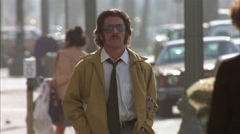 Movie still from “Straight Time” (1978), directed by Ulu Grosbard – A man in a yellow jacket is walking down the street; Medium shot, Low angle
