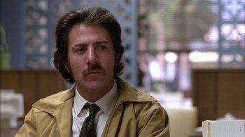 Movie still from “Straight Time” (1978), directed by Ulu Grosbard – A person wearing a suit and tie; Close Up shot, Low angle